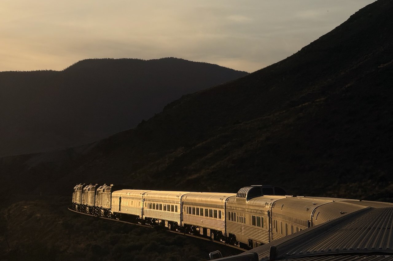 Train at sunset in mountainous landscape.