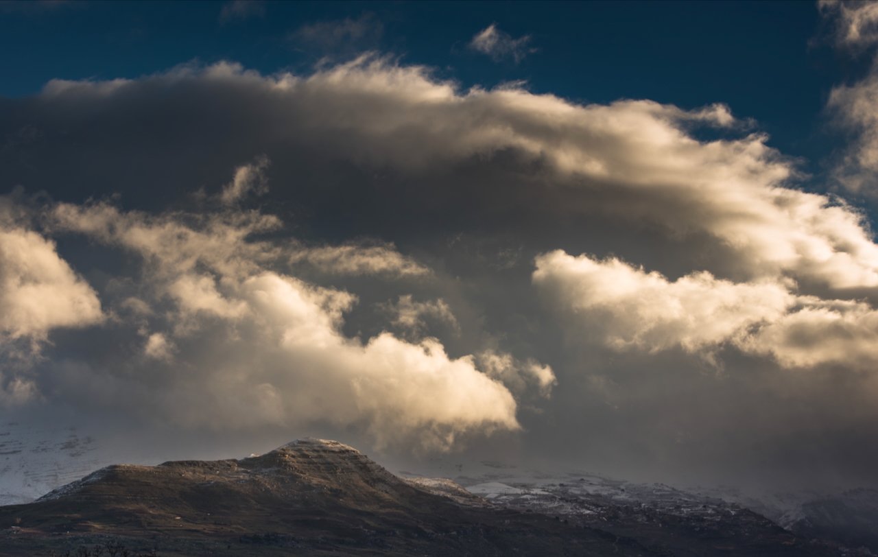 Dramatic clouds over a mountain landscape.