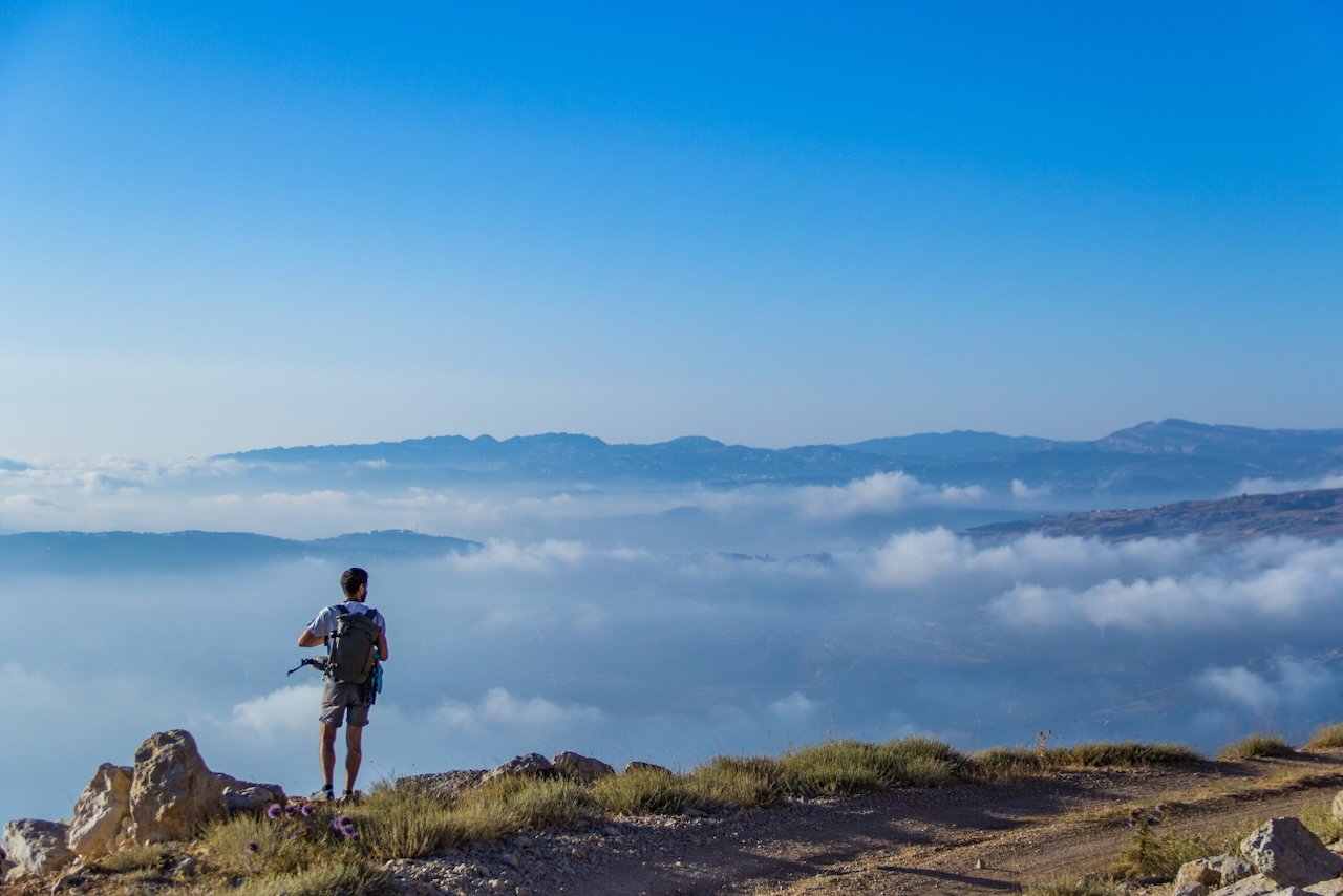 Hiker enjoying a scenic mountain view above the clouds.
