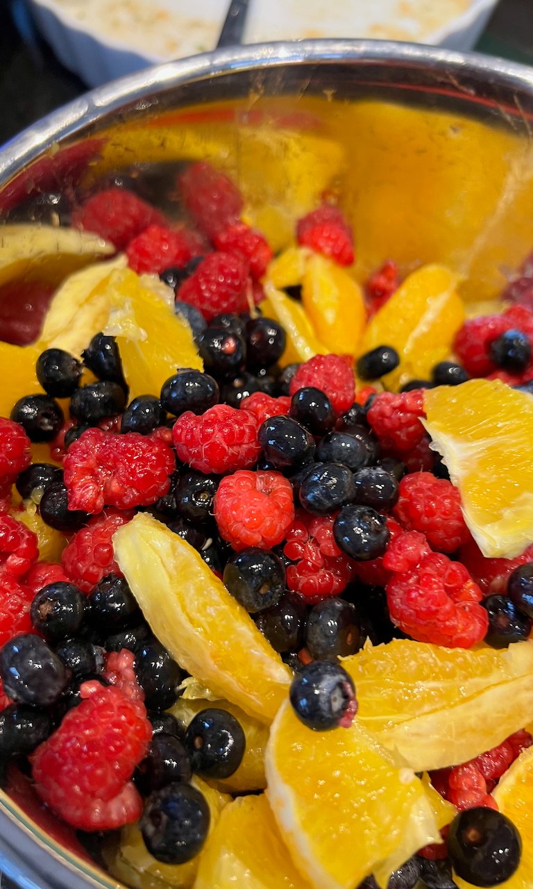 Close-up of vibrant fruit salad with oranges, raspberries, and blueberries