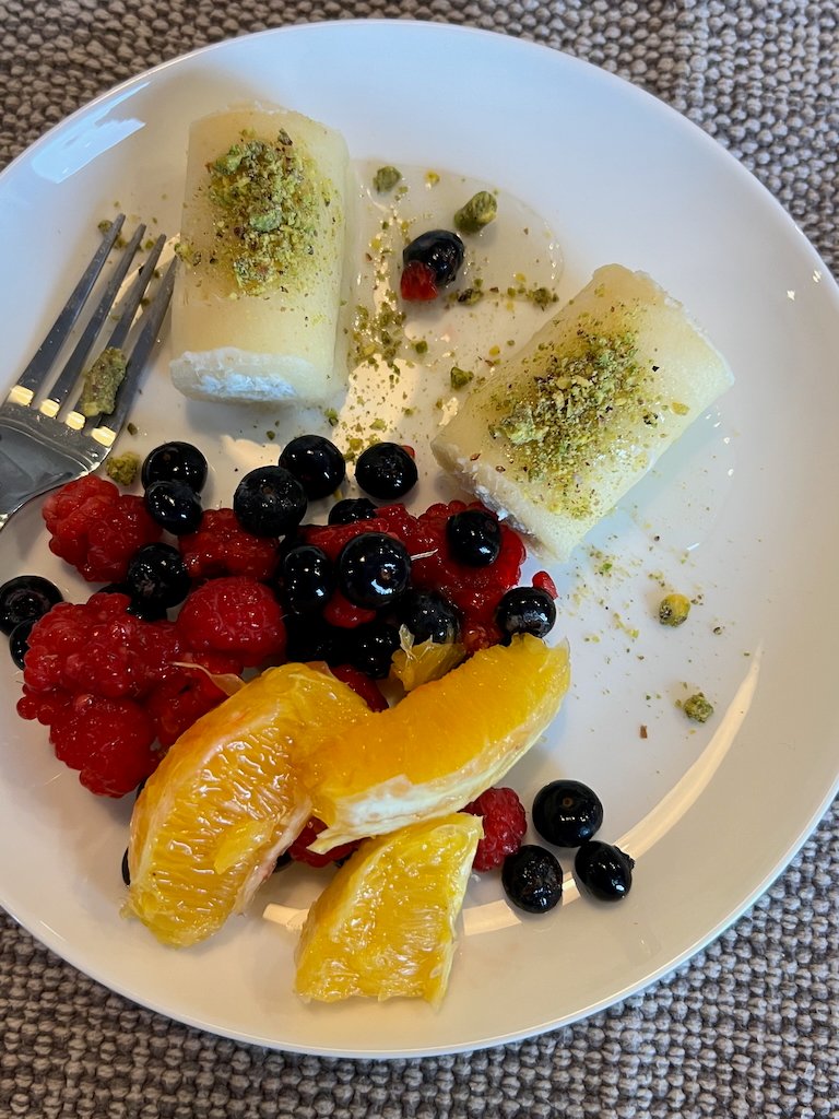 Plate with cheese rolls, raspberries, oranges, and blueberries