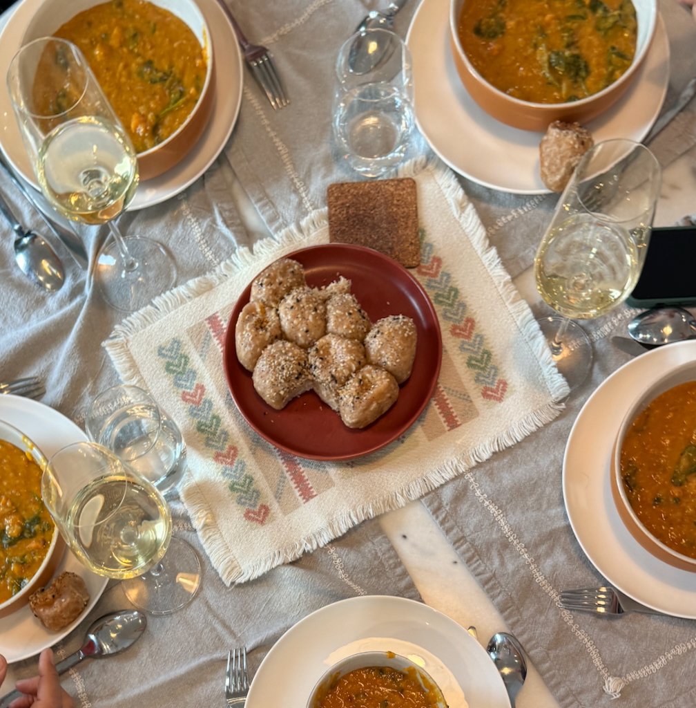Lentil soup served with whole grain bread on a shared table