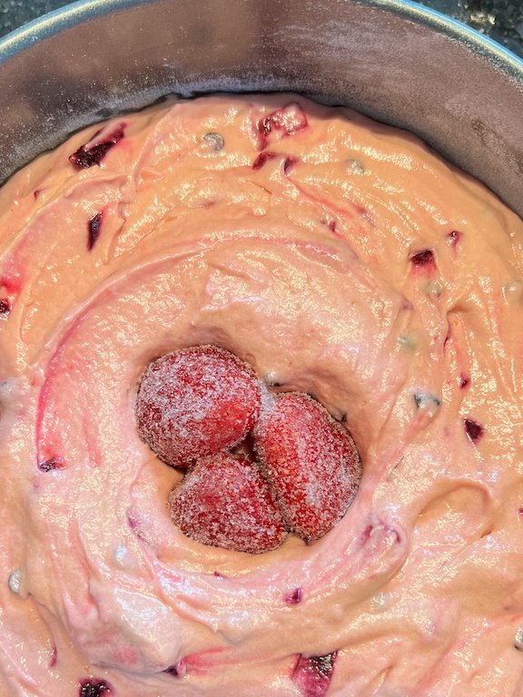 Unbaked strawberry cake batter with berries in the center