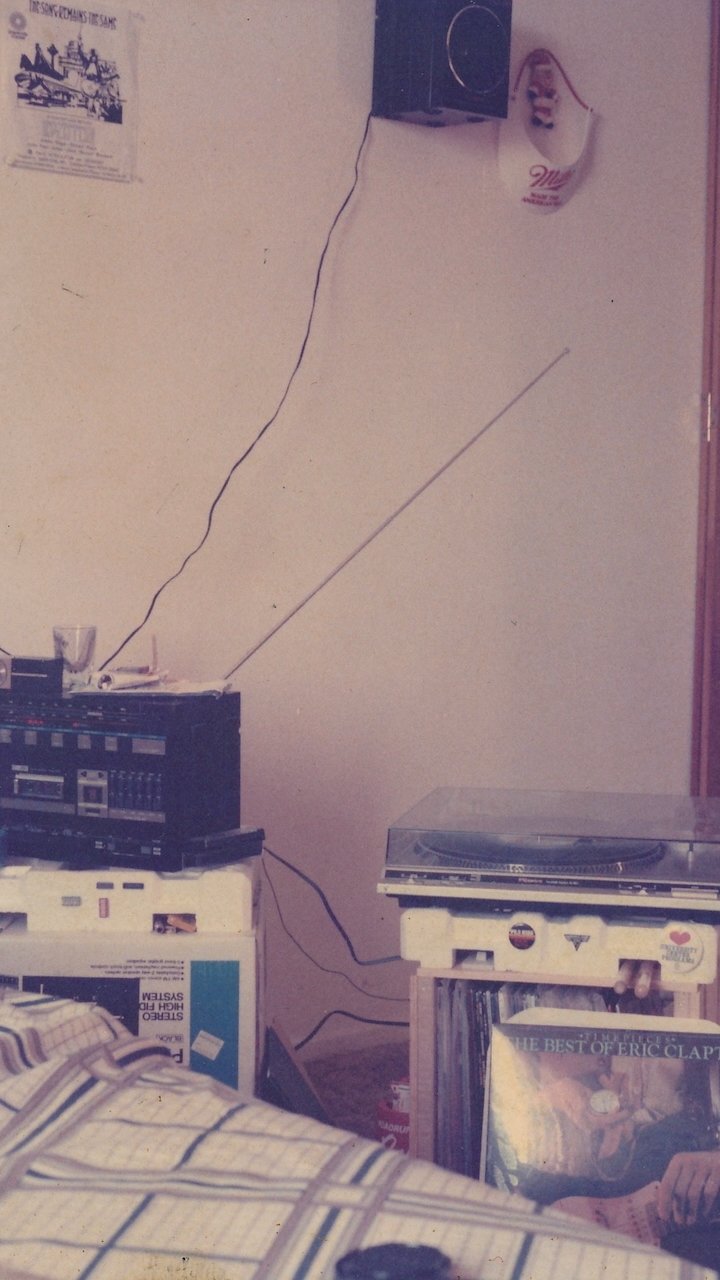A vintage room featuring a turntable and cassette player with vinyl records, showcasing a retro aesthetic and cozy atmosphere.