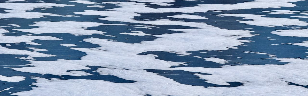 Icy lake with scattered snow creating natural abstract patterns